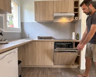 Cuisine équipée Coqys en mobil-home, homme ouvrant un lave-vaisselle